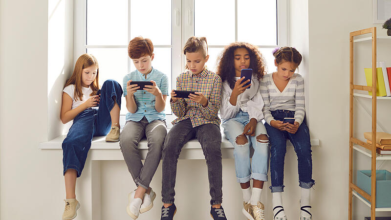 Children of different nationalities play online games or read social networks on mobile phones.