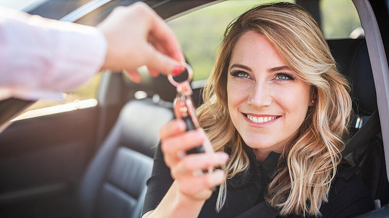 Beautiful woman gets the key from the car