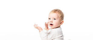 Side view of cute child kneeling with raised hands and open mouth isolated on white