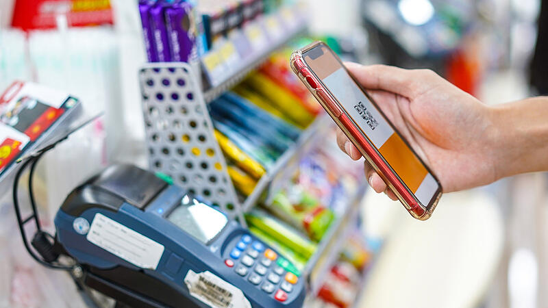 Hand of man making a contactless payment using a smartphone.