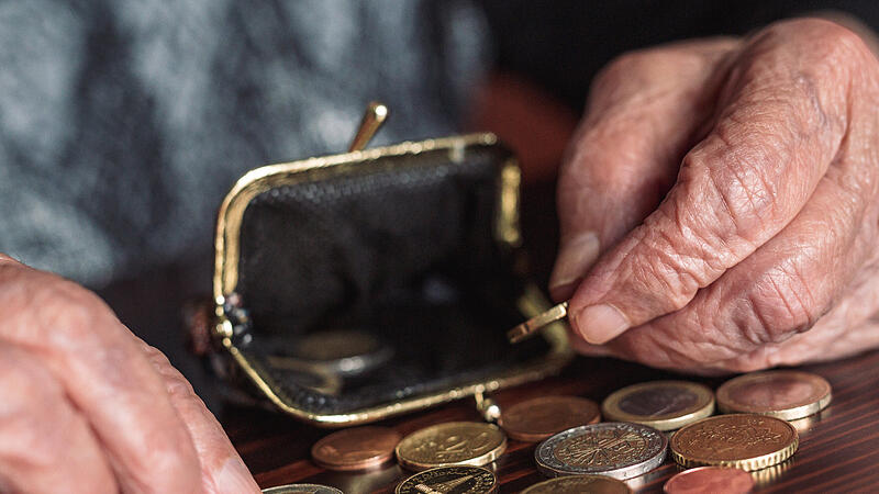 Detailed closeup photo of elderly 96 years old womans hands counting remaining coins from pension in her wallet after paying bills. Unsustainability of social transfers and pension system.