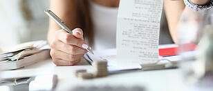 Woman hold silver pen and check in hand