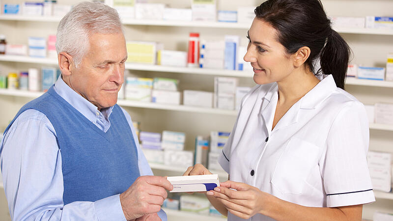 American pharmacist serving  senior man in pharmacy