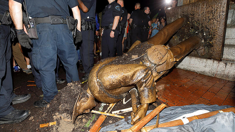 University of North Carolina police surround the toppled statue of a Confederate soldier nicknamed Silent Sam on the school's campus after a demonstration for its removal