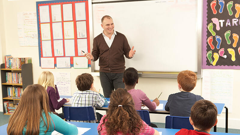 Schoolchildren Studying In Classroom With Teacher