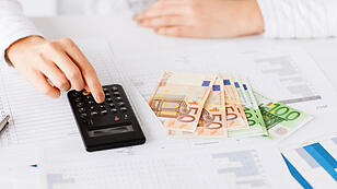 woman hand with calculator and euro money