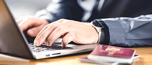 Man with passport and laptop. Travel document and identification