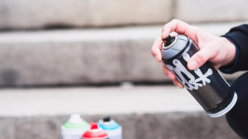 close up man s hand holding graffiti spray bottle