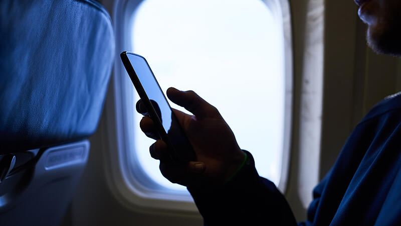 Man, hands and smartphone in airplane with journey for traveling, social media and networking. Person, traveller and happy on flight to browse internet or website for tourism tips and guideline