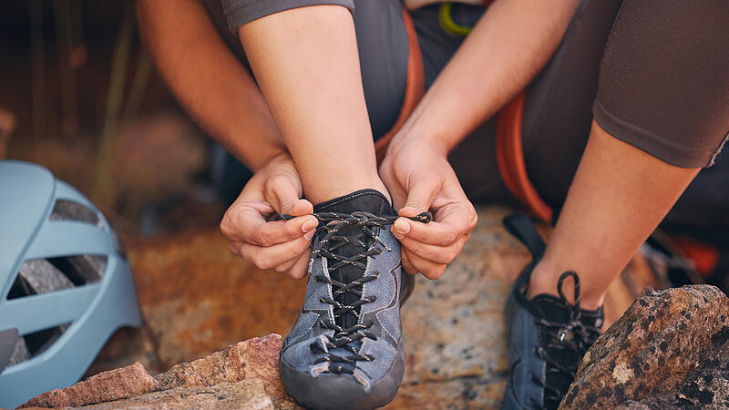 hiking shoes in nature preparing for a rock climbing or trekking exercise. Fitness, footwear and healthy girl doing outdoor sports activity or adventure on a mountain for wellness.