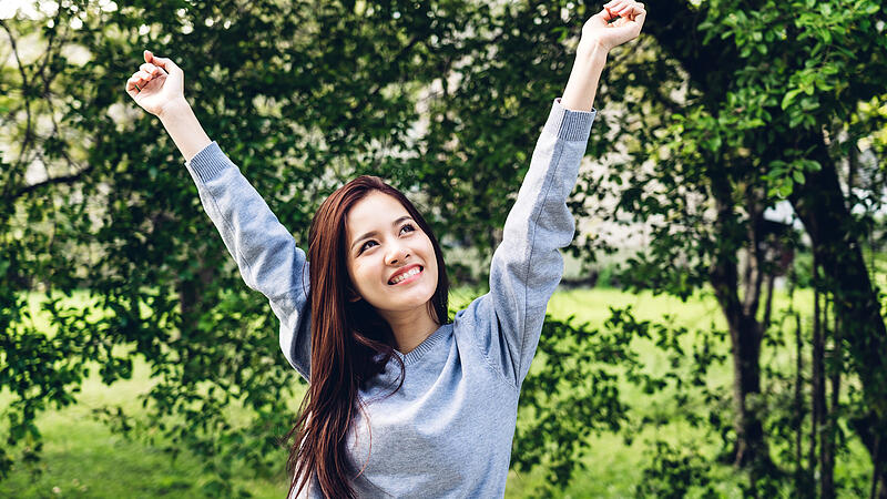 Asia woman standing stretch her arms relax and enjoy with nature