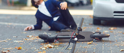 Accident with an electric scooter. A man fell from a scooter on a city street.