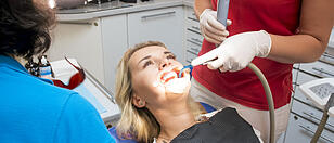 Closeup image of dentist assistant using saliva ejector