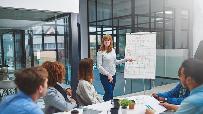 Shes got their full attention. Shot of a young businesswoman using a whiteboard to give a presentation to her colleagues in a boardroom.