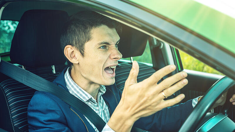 Angry man driver screaming in the car. Quarrel and dissatisfaction on the way.