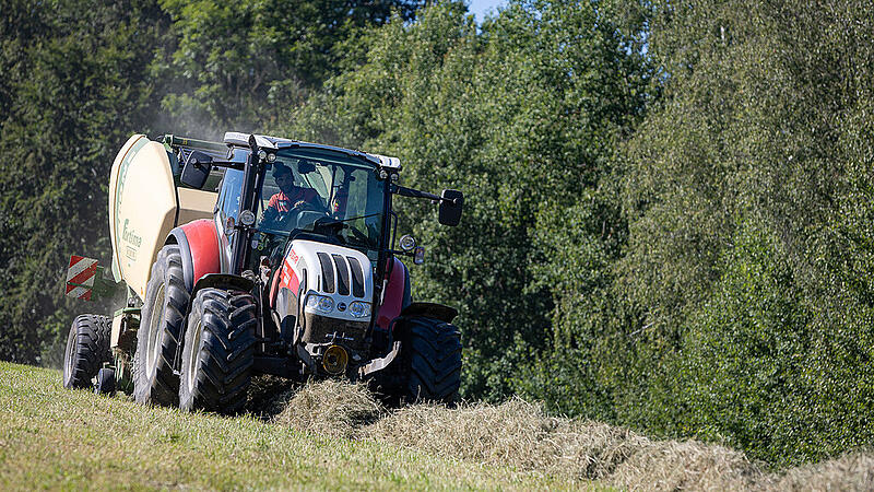 Landwirt beim Heuballen pressen