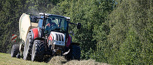 Landwirt beim Heuballen pressen